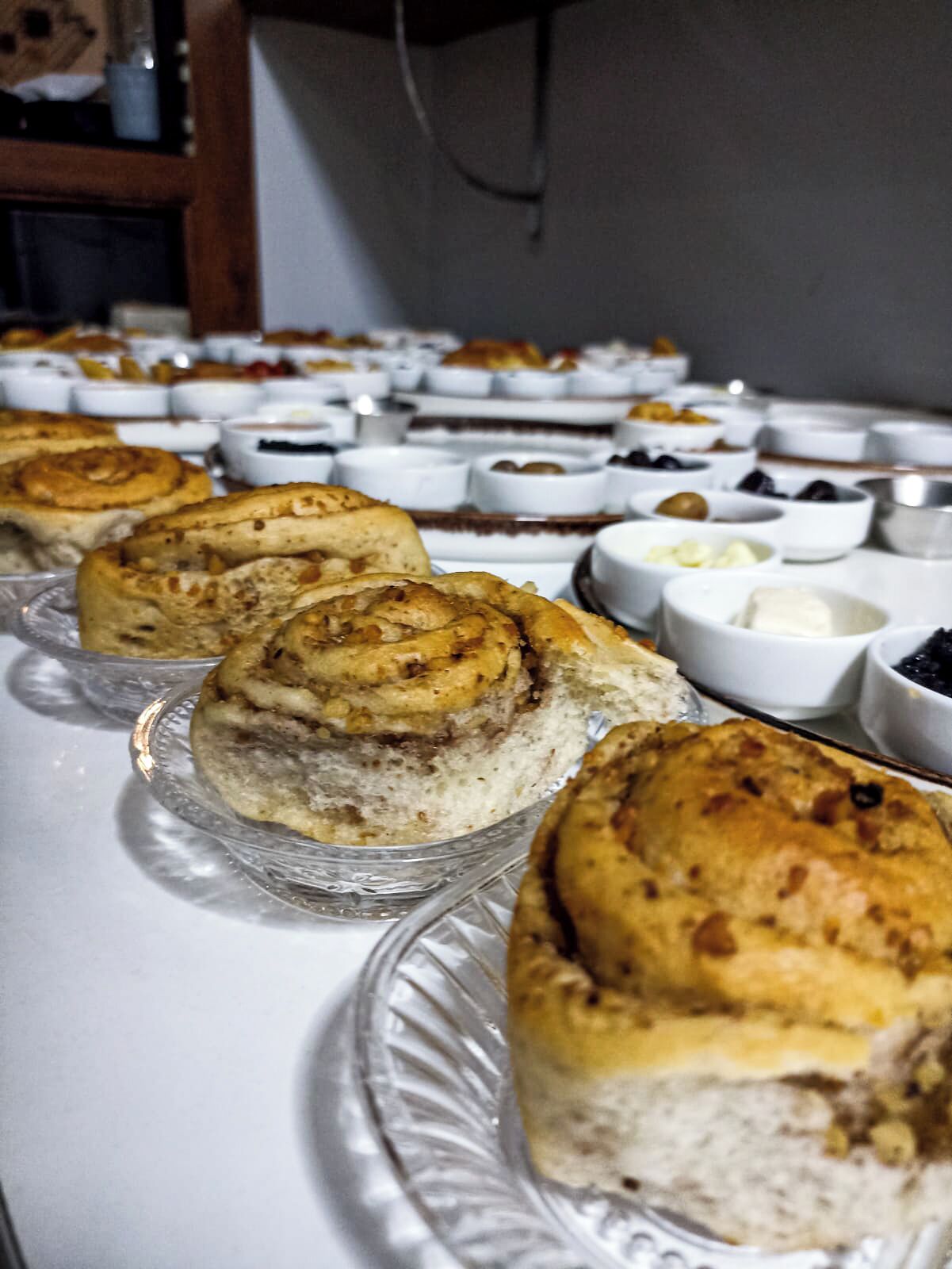 A buffet table with various pastries and desserts, including cinnamon rolls and other baked goods.