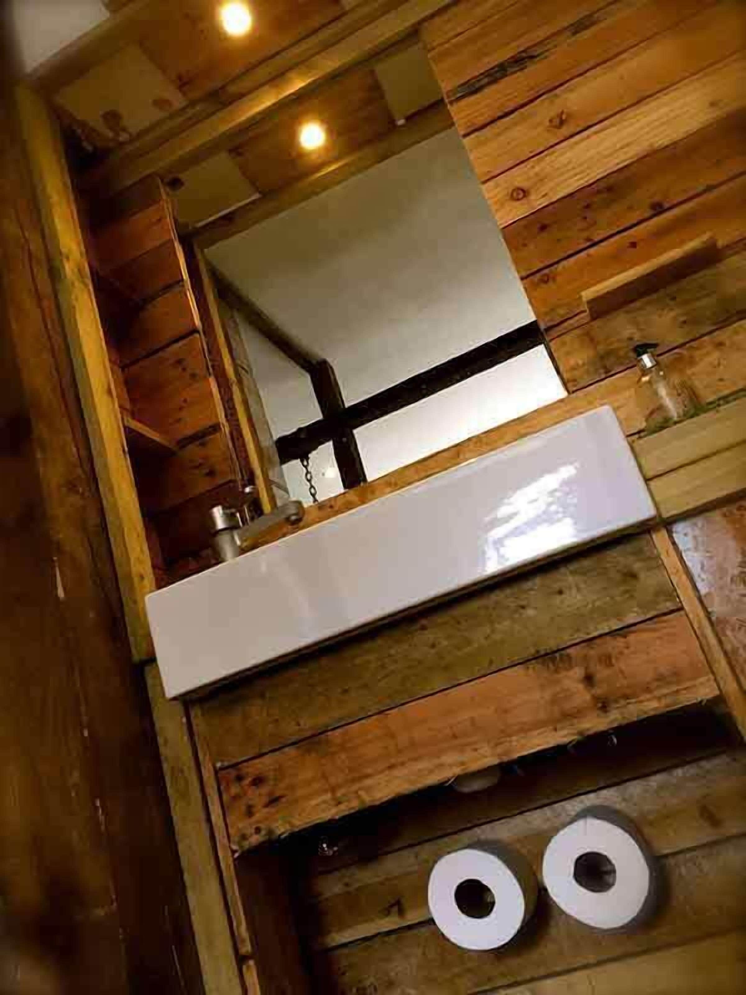 L’intérieur d’une cabane en bois, avec un plafond en bois, un comptoir blanc et un miroir.