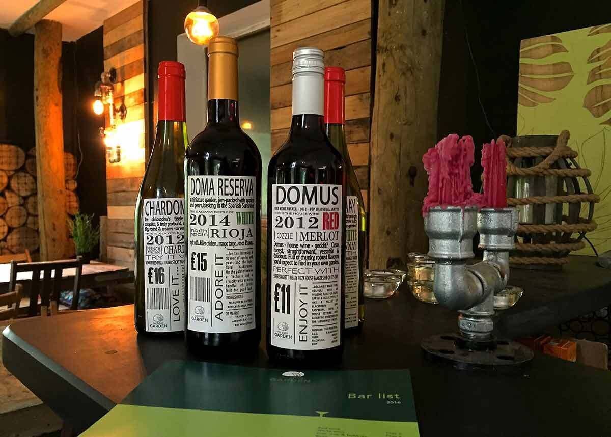 Three wine bottles on a bar counter with a rustic background.