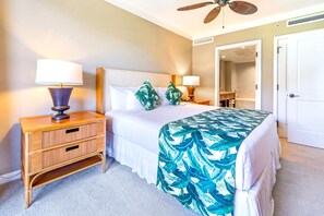 A hotel room with a bed, a nightstand, a lamp, a ceiling fan, and a door. - Honua Kai | Ocean View 2 BR | Free Car w/ 6+ Nights | HKH-348 (Lahaina)