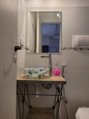 Een douche, handdoeken, zeep, toiletpapier