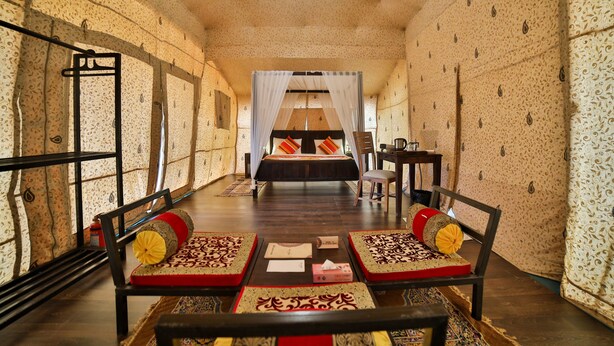 A hotel room with a bed, two chairs, a table, and a desk. - Rann Utsav The Tent City (Bhuj)