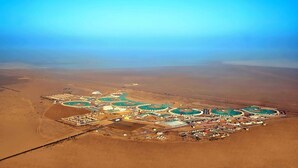 An aerial view of a resort with multiple swimming pools, a central building, and a desert landscape. - Rann Utsav The Tent City (Bhuj)