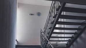 Un escalier avec des rampes en métal menant à un palier.