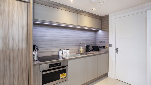 A modern kitchen with stainless steel appliances, a built-in oven, and a sink.