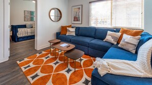 A living room with a blue sofa, a coffee table, and a patterned rug.