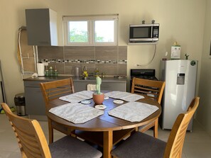 A compact kitchen with a microwave, stove, and refrigerator. - LiCe 's Garden Aruba (Paradera)