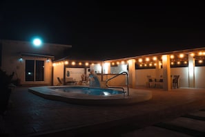 A pool area with a hot tub, surrounded by a covered patio with string lights. - LiCe 's Garden Aruba (Paradera)