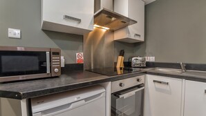 A compact kitchen with a microwave, toaster, and dishwasher. - Gillygate Boutique Apartment - sleeps 4 guests  in 1 bedroom (York)