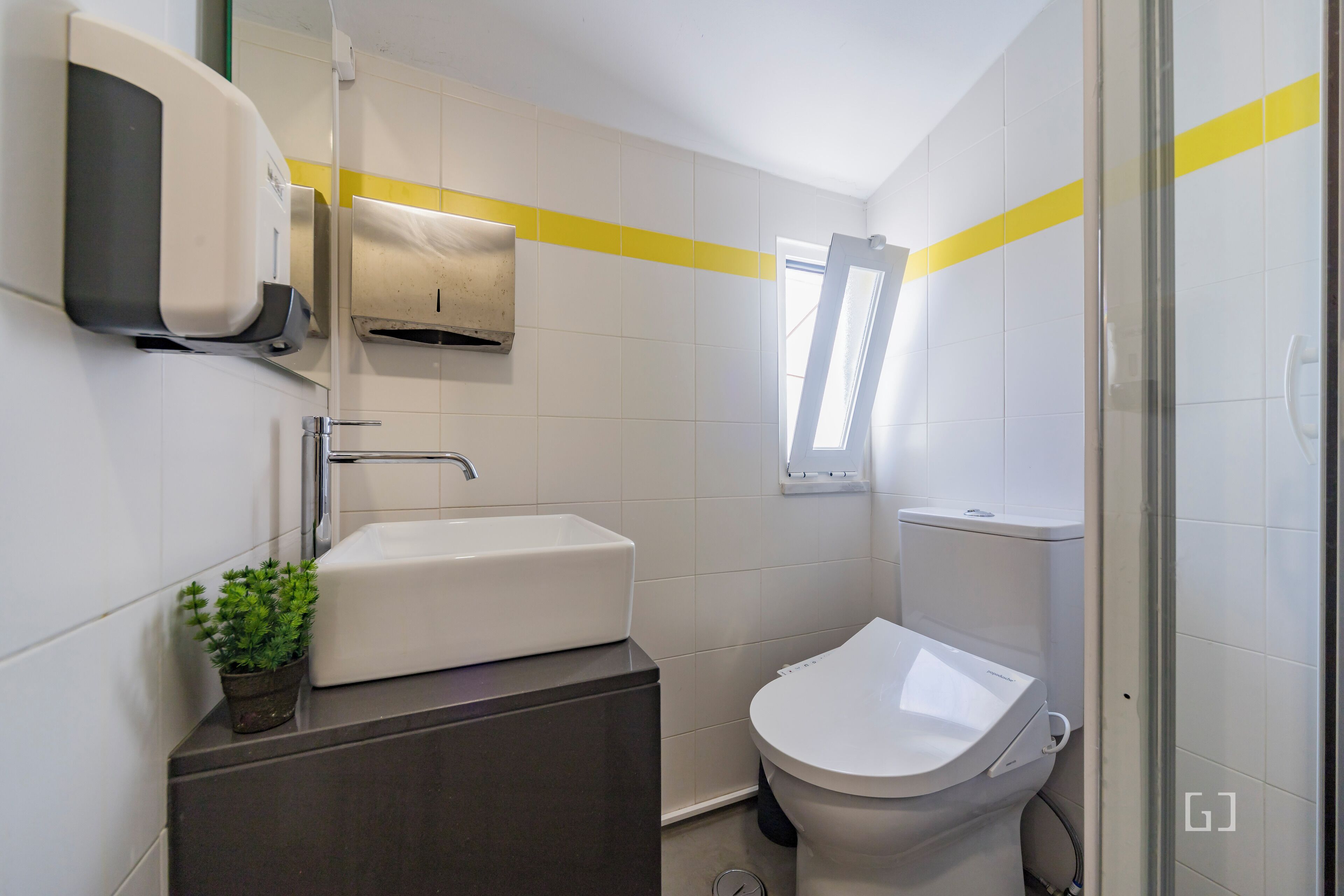 Une salle de bain moderne avec un lavabo blanc, des toilettes et un espace douche.