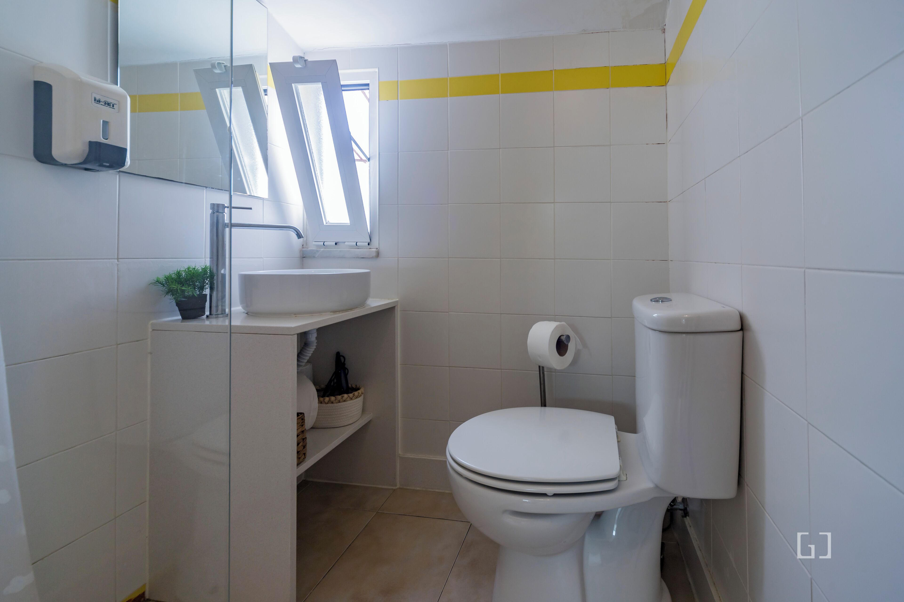 A small bathroom with a toilet, sink, and a mirror.