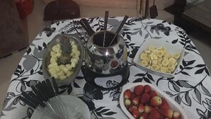 Ett bord med olika sorters mat och en öppen spis i bakgrunden.