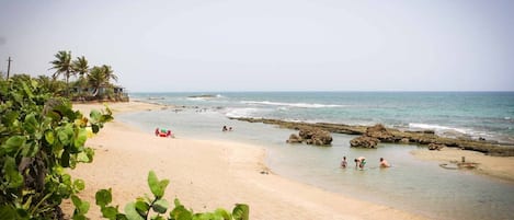 Na praia, espreguiçadeiras, toalhas de praia 