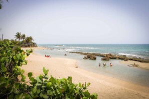 Rannalla, aurinkotuoleja, rantapyyhkeitä