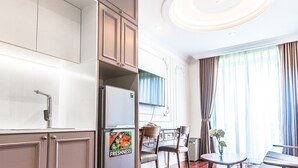 Quarto de hotel moderno com cozinha, mesa de jantar e uma grande janela com cortinas.