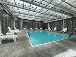 Una piscina al aire libre, sillones reclinables de piscina