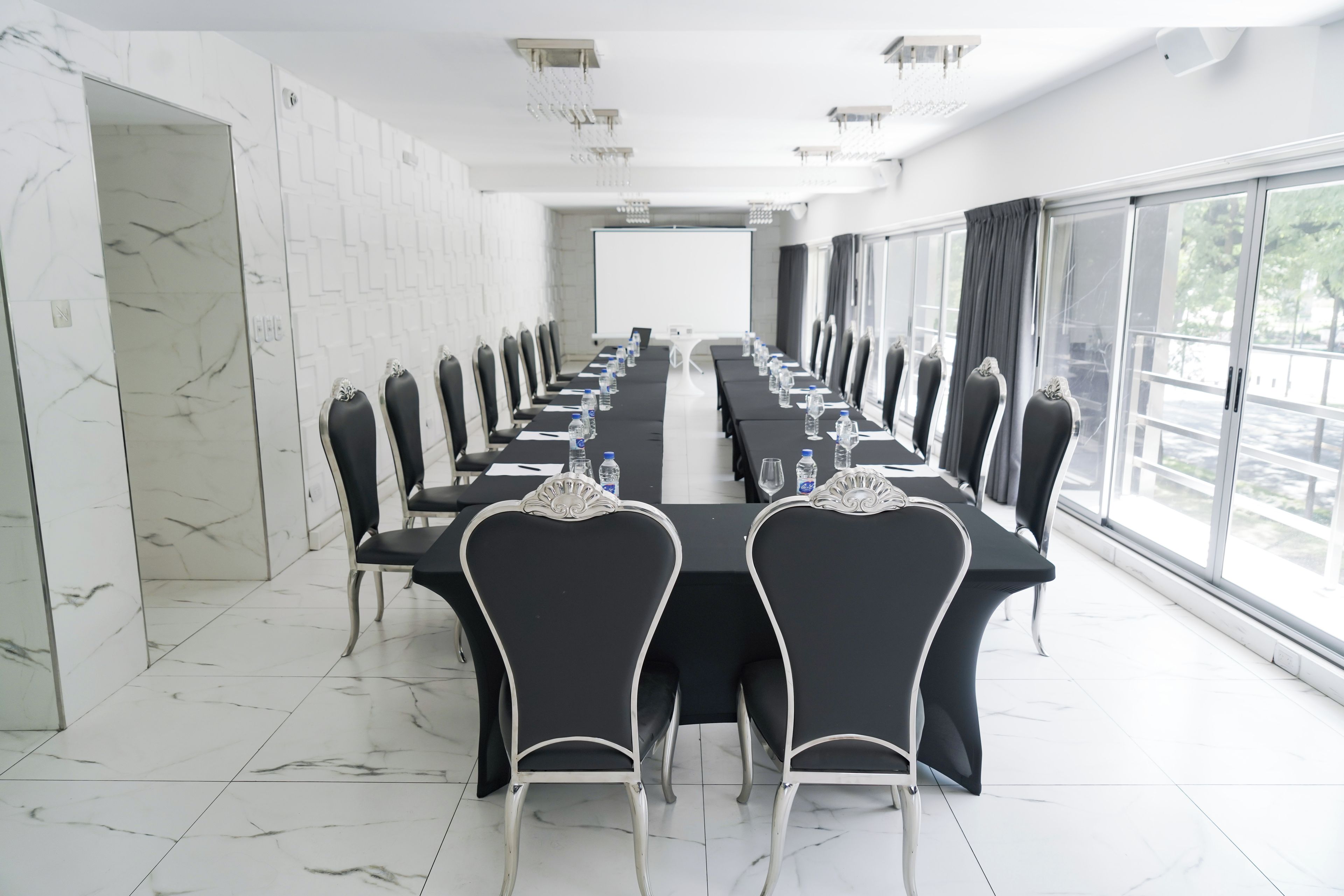 Une salle de conférence équipée d’une longue table, de chaises et d’un écran de projection.