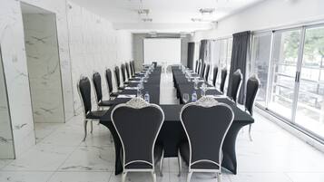 Une salle de conférence équipée d’une longue table, de chaises et d’un écran de projection.