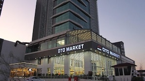 A modern building with a large glass facade and the sign "OTO MARKET" prominently displayed. - Grand Rimedya Hotel Bursa (Bursa)