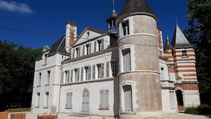 Een groot, historisch gebouw met meerdere torens en een opvallende torenspits.