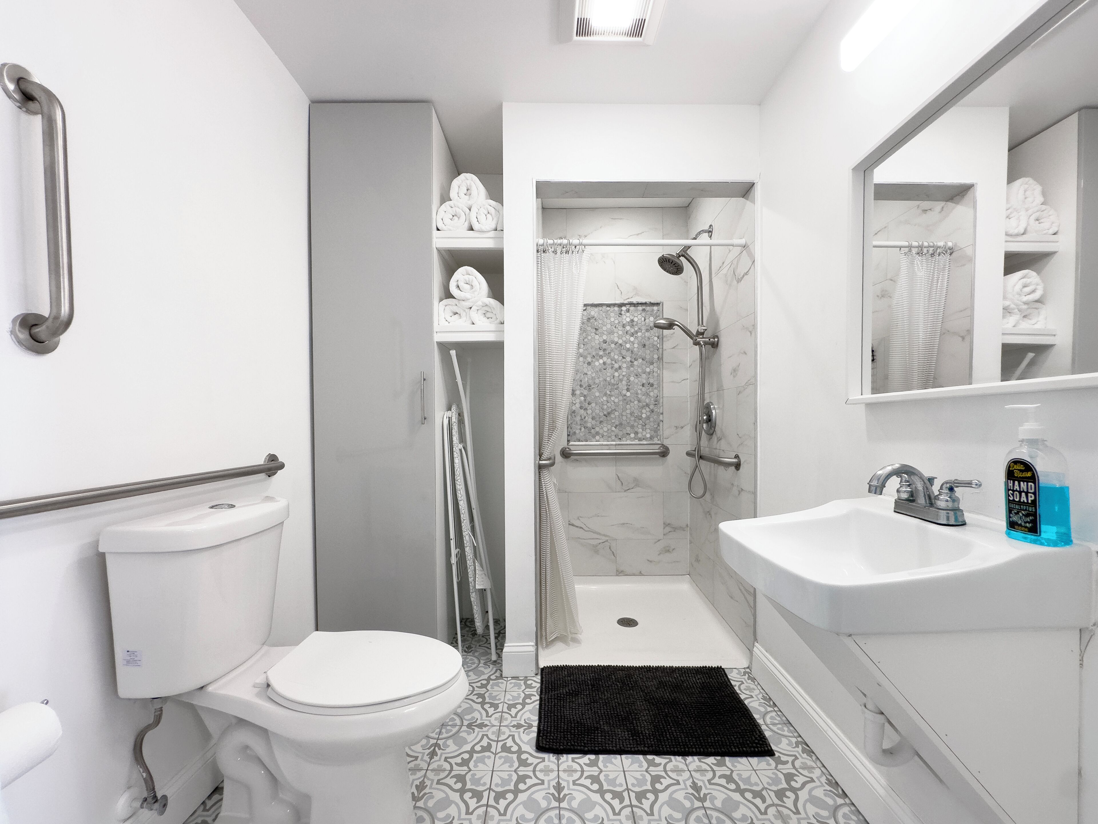 Et moderne badeværelse med toilet, håndvask og brusebad.