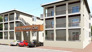A multi-story building with balconies and a sign reading "5100 Vacation Club".