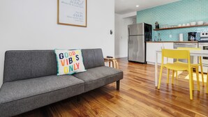 A modern kitchen with a stainless steel refrigerator, a coffee machine, and a sink.