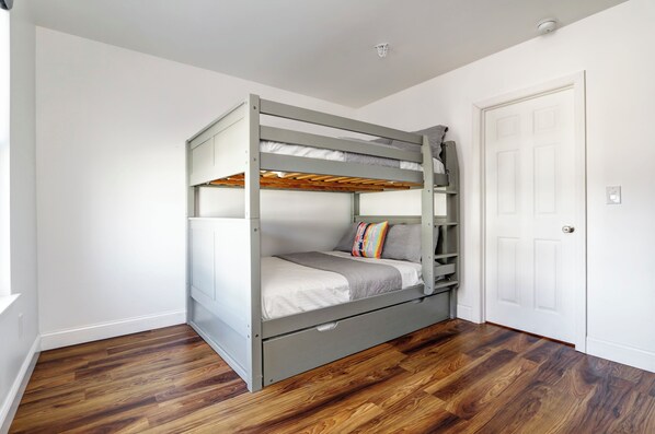 A bunk bed in a room with wooden flooring and a white door. - 5100 Vacation Club (Wildwood)