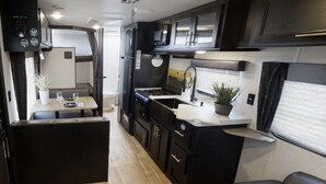 Cocina compacta para autocaravana con comedor, pequeña kitchenette y zona de estar.