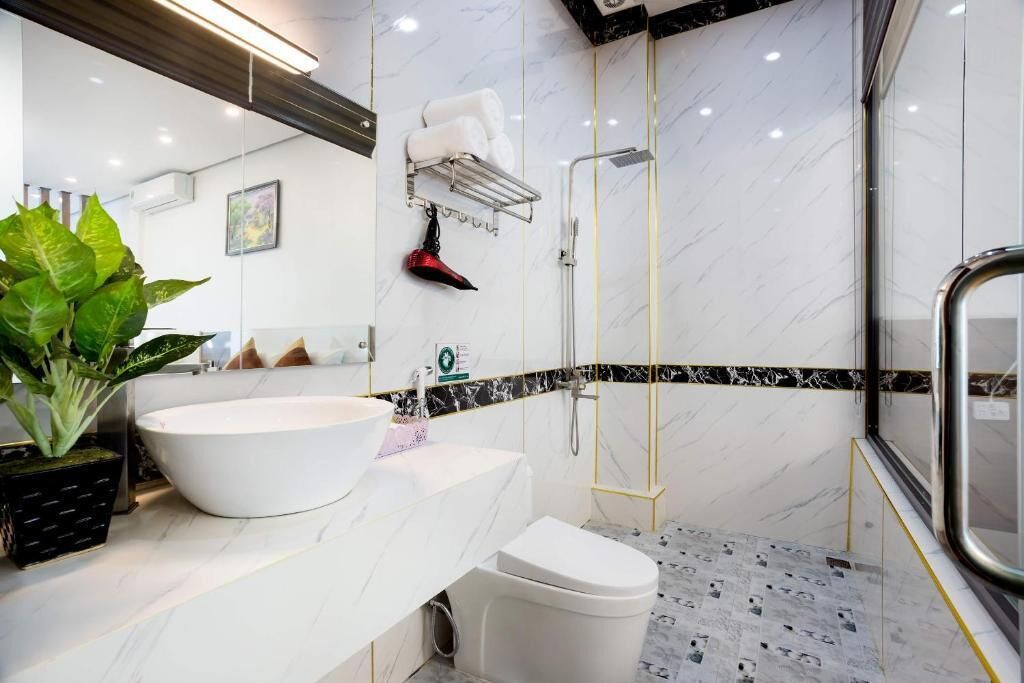 Un baño moderno con lavamanos, inodoro y ducha blancos.
