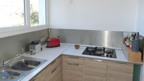 A modern kitchen with a gas stove, a red toaster, and a sink. - HOUSE BETWEEN COUNTRYSIDE AND SEA (Saint-Julien-en-Born)