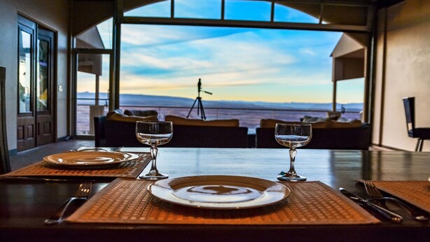 Une table à manger dressée avec des assiettes et des verres, offrant une vue panoramique.
