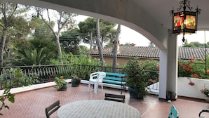 A covered outdoor area with a round table, benches, potted plants, and a decorative lantern. - St RAPHAEL 400m from the beach 2 bedrooms sleeps 6 (Saint-Raphaël)