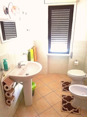 A bathroom with a sink, toilet, and window with blinds. - B&B Relax Damiani (Laureana Cilento)