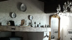 Un salon traditionnel avec une cheminée, un tapis à motifs et un lustre.