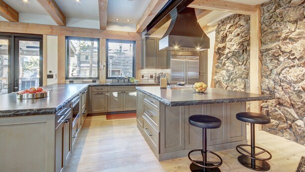 A spacious kitchen with a large island, wooden beams, stone wall, and modern appliances. - Experience luxury in this 4-bedroom, 3.5-bath home in Breckenridge at Arrow Darrow! (Breckenridge)