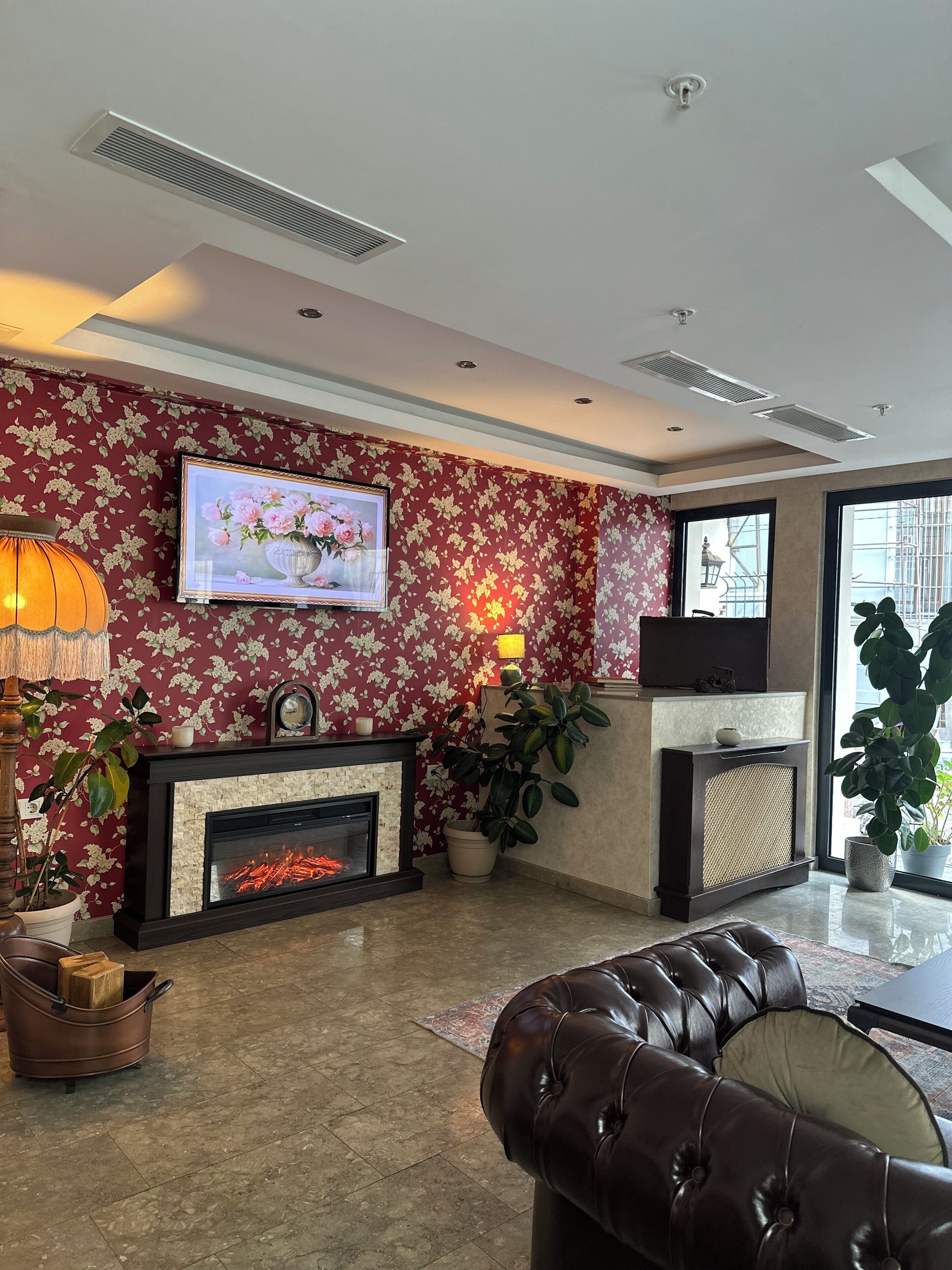 A living room with a fireplace, a television, and a large window.
