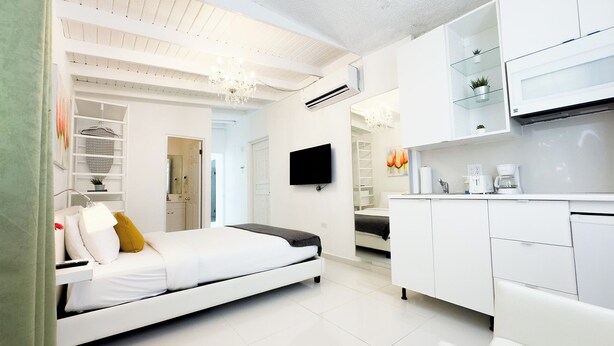 Une chambre à coucher moderne avec un lit, une table de chevet et un téléviseur fixé au mur.