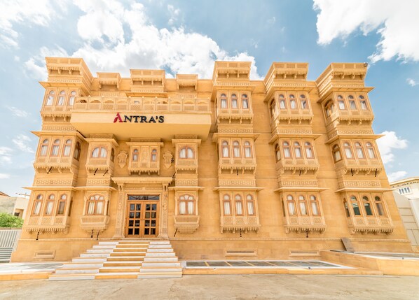 A large, ornate building with multiple balconies and a sign reading "ANTRA'S".