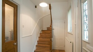 A wooden staircase with a white wall and a door with frosted glass. - Victoria's place (Chelmsford)