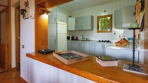 A kitchen with white cabinets, a wooden countertop, a window, and a sink. - GC0152 Holiday cottage in La Lechuza (Vega de San Mateo)