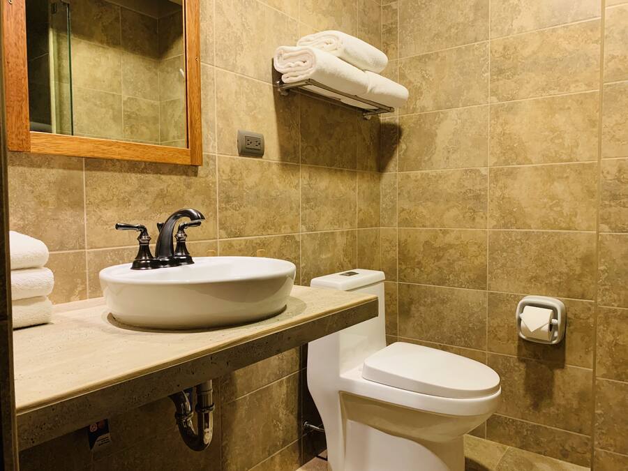 A bathroom with a sink, toilet, and a towel rack.