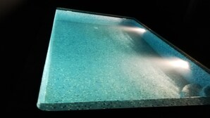 Ein rechteckiger Pool mit gefliestem Rand und dunkler Umgebung.