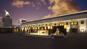 A hotel with a modern facade, multiple entry points, and a central courtyard with a fountain.