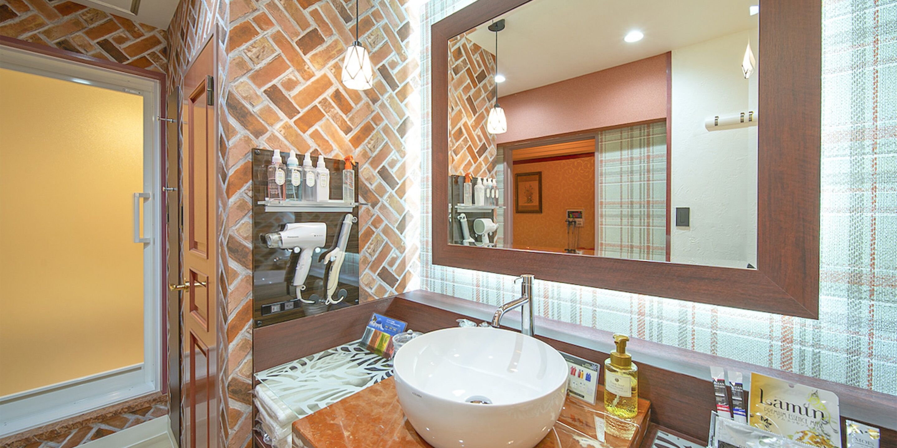 A bathroom with a large mirror, a sink, and toiletries on the counter.