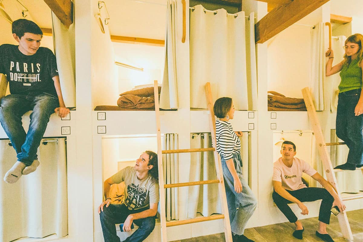 A room with bunk beds, wooden ladders, and a simple, functional design.