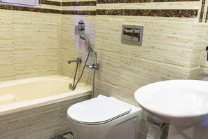 A bathroom with a bathtub, toilet, and sink.