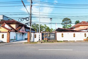 Vista de una calle con un edificio que dice 'M. P. Resort' y cielo despejado.