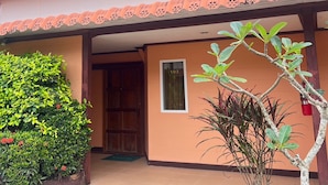 A building with a number 103 sign, a wooden door, and a tiled roof.
