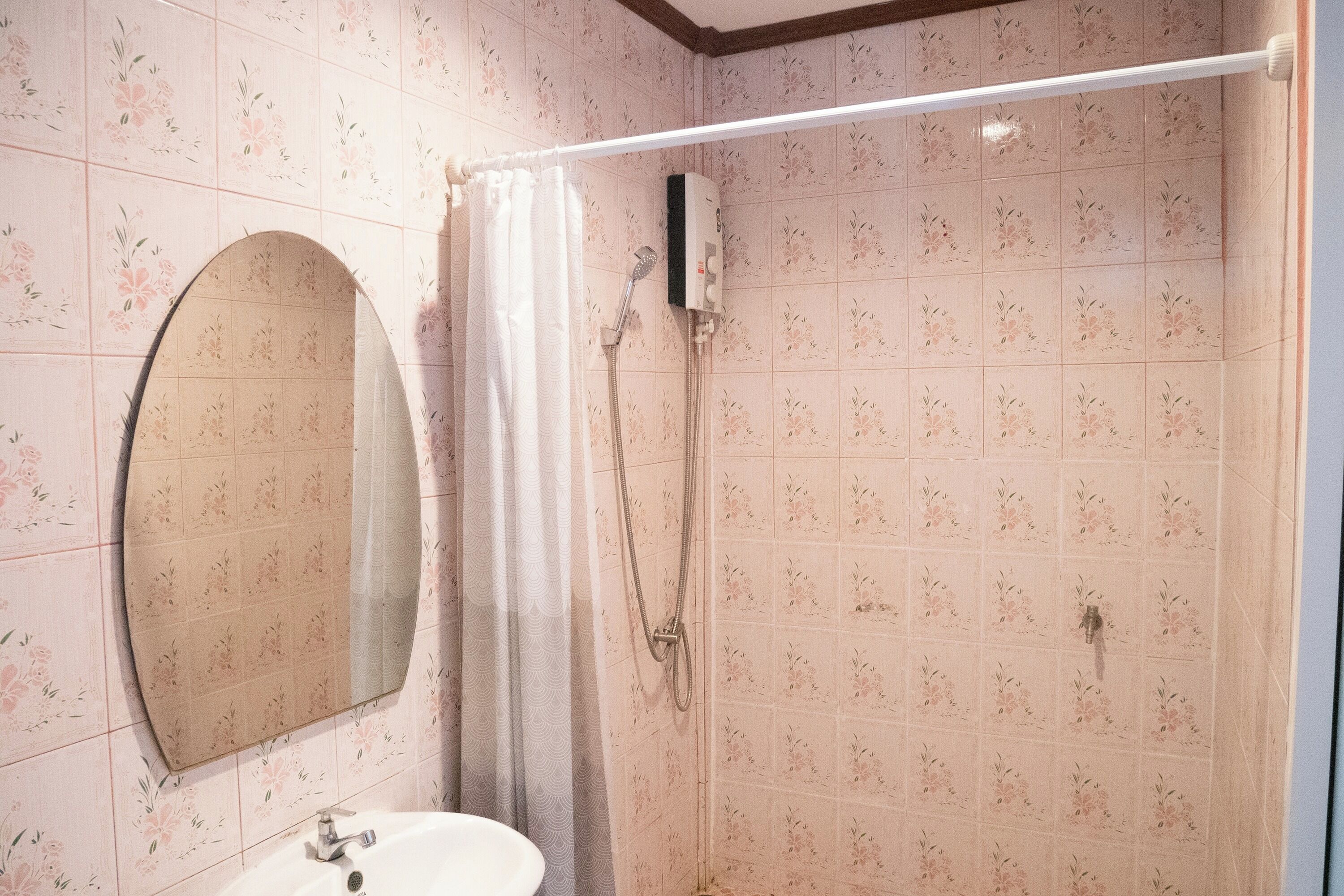 A bathroom with a shower, a sink, and a mirror.